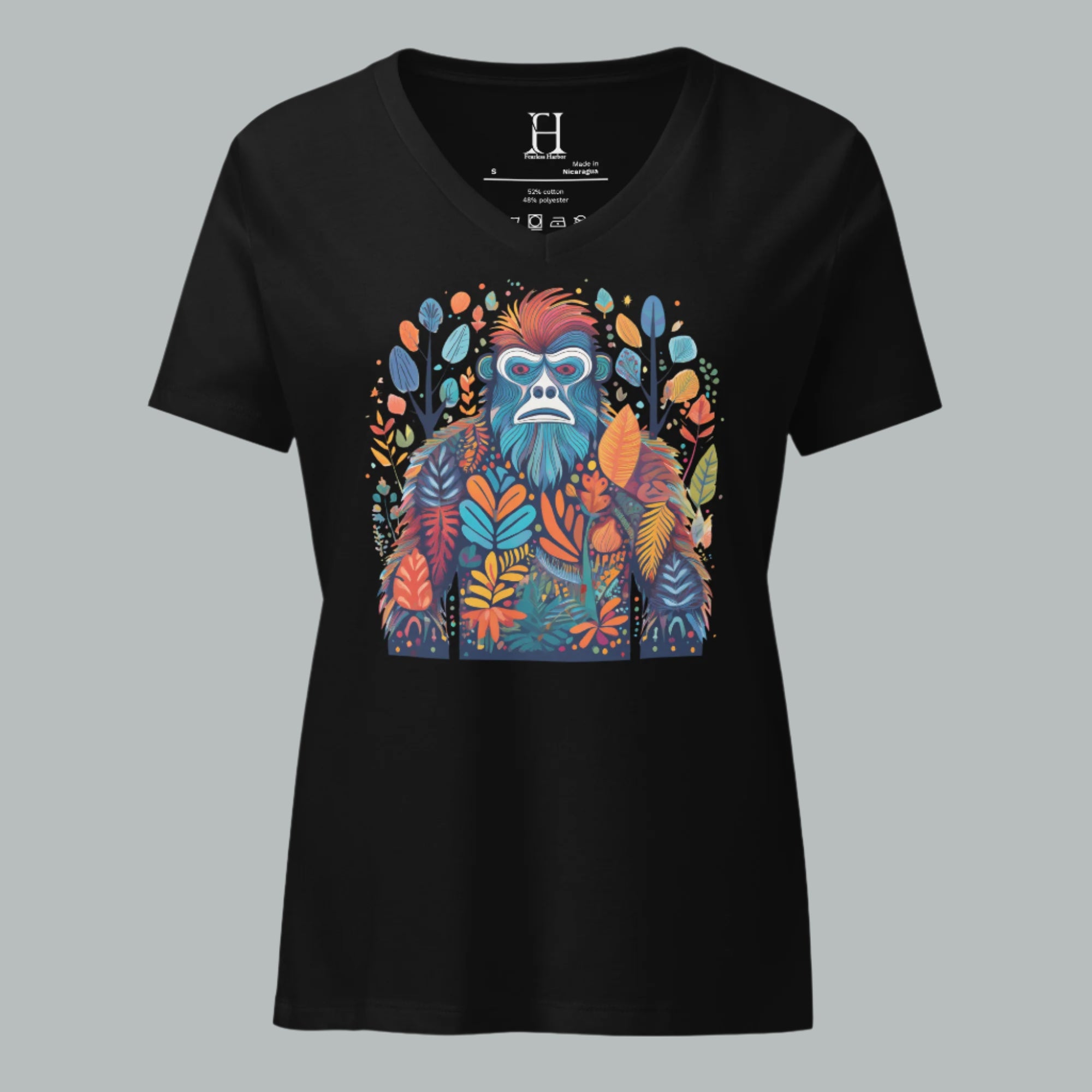 Front of women’s V-neck tee in solid black blend featuring a multicolored Bigfoot camo graphic with layered trees.