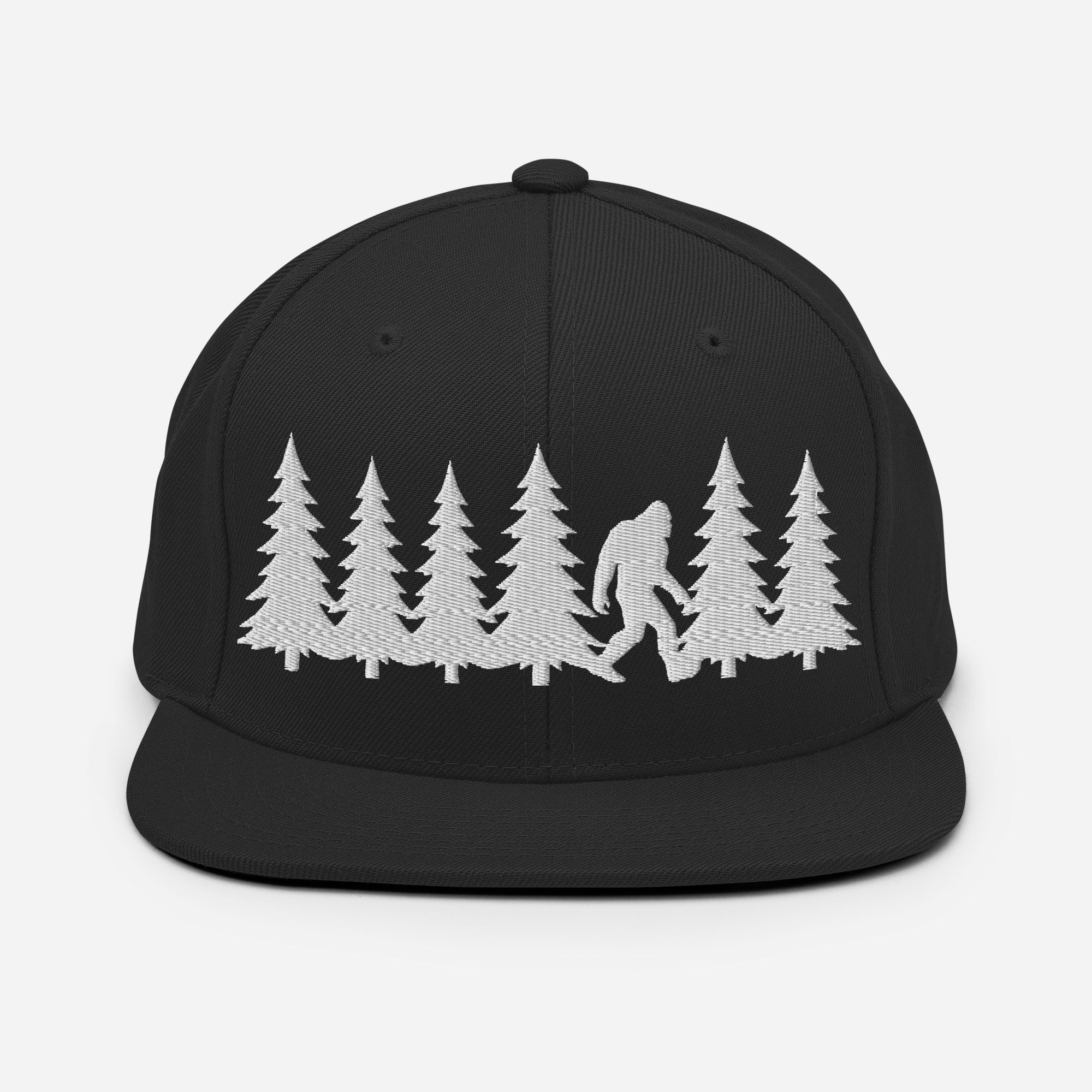 Front view of black trucker hat featuring a white embroidered Bigfoot silhouette walking through pine trees.
