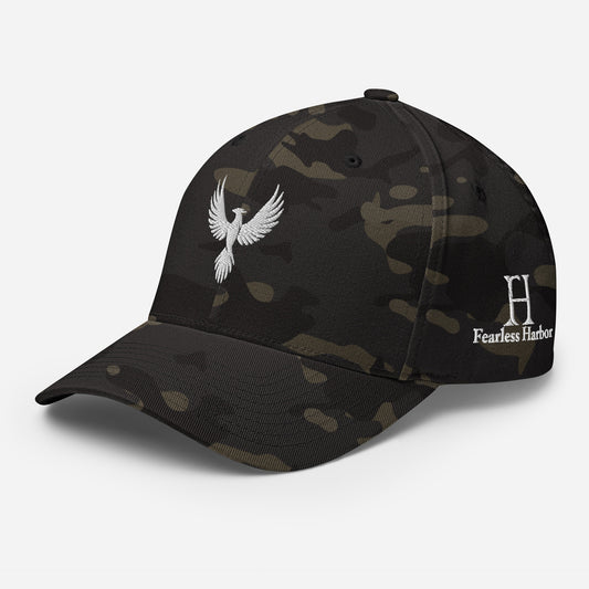 Left Front of FlexFit Hat in Multicam Black with white phoenix logo embroidery on front and FH logo on left side.