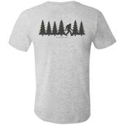 Back view of the Men’s Fade Into the Pines Bigfoot Core Tee in Athletic Heather showing a walking Bigfoot silhouette moving through a row of pine trees with the words fade into the pines.