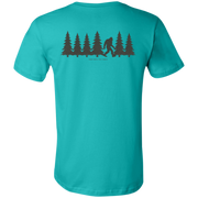 Back view of the Men’s Fade Into the Pines Bigfoot Core Tee in Teal showing a walking Bigfoot silhouette moving through a row of pine trees with the words fade into the pines.
