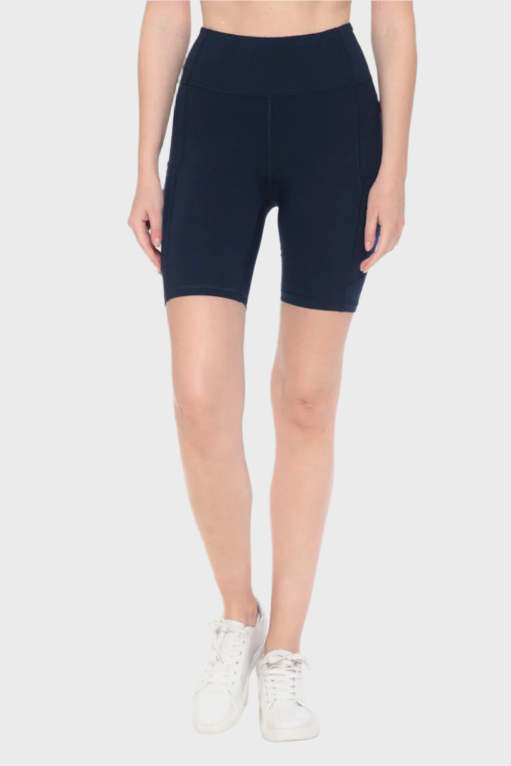 Front of woman wearing Full Size High Waist Active Shorts in Navy, blank with no graphics or text.