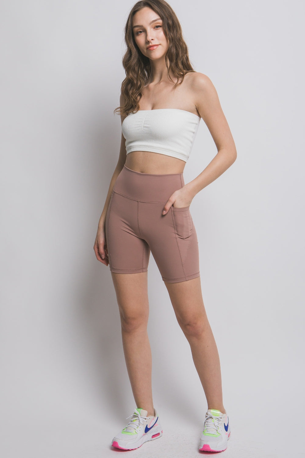 Front of woman wearing High Waist Seam Detail Active Shorts in Taupe, blank with no graphics or text.