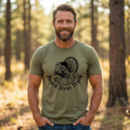 Front of Man wearing a Fearless Harbor premium turkey hunting shirt with a front strutting wild turkey graphic in a spring woods hunting setting in Olive Color.