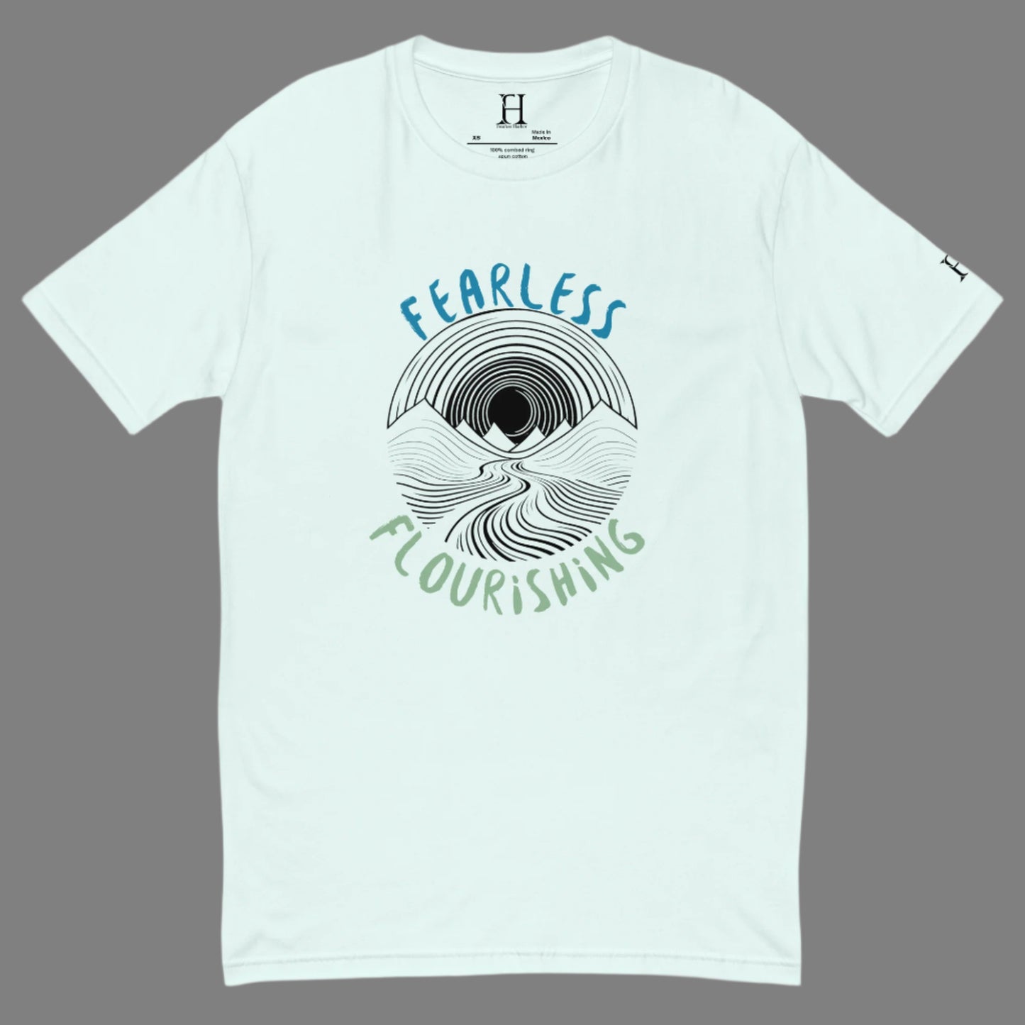 Front of light blue T-shirt with black outline of a river flowing through mountains and the words Fearless and Flourishing.