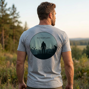 Back of Wild Never Sleeps Bigfoot Duck Hunting Premium Tee in Athletic Grey highlighting a marsh side Bigfoot silhouette, a duck hunter in cover, flying ducks, and Wild Never Sleeps text.