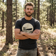 Front of man wearing Not All Shadows Are Animals Bigfoot Archery Premium Tee in Charcoal Triblend featuring a circular graphic of large bowhunter and their shadow reflecting that of a Sasquatch.