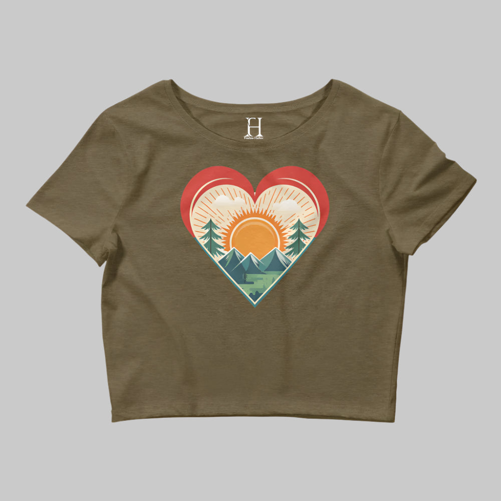 Front of Bold Crop Top Tee in Olive, with sun rising over a forest within a heart silhouette design.