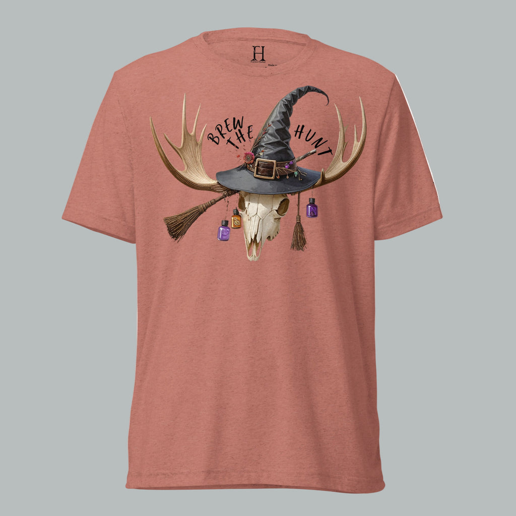 Front view of Fearless Harbor Women's Brew the Hunt Tee in Mauve featuring skull with antlers, witch hat, and broomstick design.