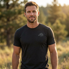 Man outdoors wearing the Men's First Light Crew Waterfowl Tee in Solid Black Triblend front view with Public Marsh emblem