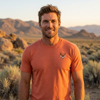 Man outdoors wearing the Men's High Desert Bowline Mule Deer Tee in Heather Orange front view showing the mule deer chest emblem