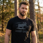 Man outdoors wearing the Men's Swamp Ghost Triblend Tee in Solid Black Triblend front view in a natural hunting lifestyle setting